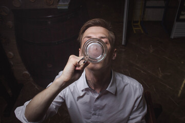 The man finishes his beer. Male drink. Rest after a working day. Alcoholic drink. High quality and tasty beer.