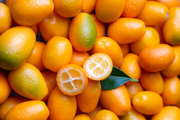 Top view of bunch of fresh kumquats in the organic food market. Some kumquats is cutted