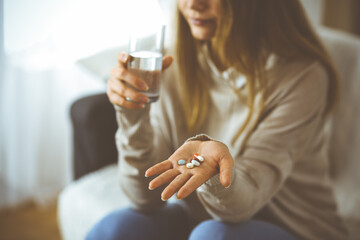 Close-up woman holding pills time to take medications, cure for headache, high blood pressure or...