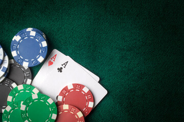 Stack of chips and two aces on the table on the green baize - poker game concept