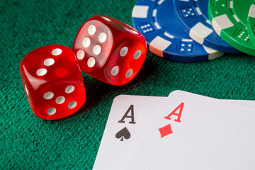 Stack of chips and two aces on the table on the green baize - poker game concept