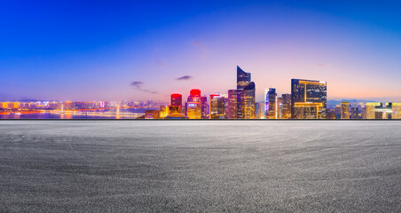 Race track road and modern city skyline with buildings in Hangzhou at night.
