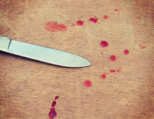 pocket knife blade and blood drops on wooden floor