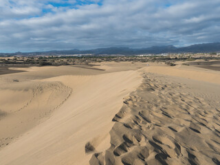 View of the Natural Reserve of Dunes of Maspalomas, golden sand dunes, blue sky. Gran Canaria, Canary Islands, Spain