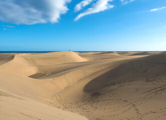 View of the Natural Reserve of Dunes of Maspalomas, golden sand dunes, blue sky. Gran Canaria, Canary Islands, Spain