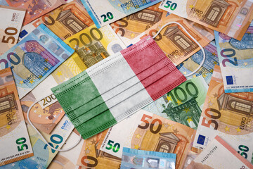 Obraz na płótnie Canvas Medical mask with the flag of Italy on a variety of european banknotes.(series)
