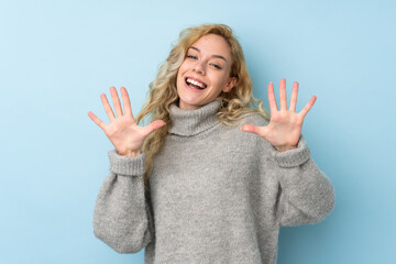 Young blonde woman wearing a sweater isolated on blue background counting ten with fingers