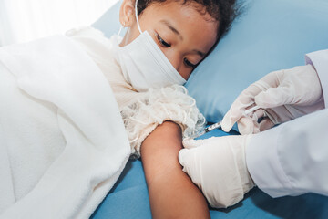 The doctor is vaccinating Prevent Covid-19 or Coronavirus for 5-year- old girl is mixed race African, who wearing a surgical masks Lying in patient bed, to vaccine concept.