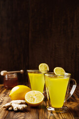 Fototapeta premium Glass cups of lemon ginger lemonade and ingredients vertical shot with copy space