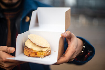 Traditional danish fastelavnsboller with crispy flaky dough and whipped cream on top and powdered...