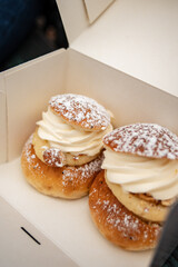 Traditional fastelavnsboller semla semlor swedish february dessert, traditional scandinavian sweet bread with almond cream paste and whipped cream. Cardamom bun and powdered sugar delicious treat