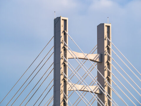 Steel wires bridge structure. Close up with metal cable structure of a modern suspension bridge against blue sky.