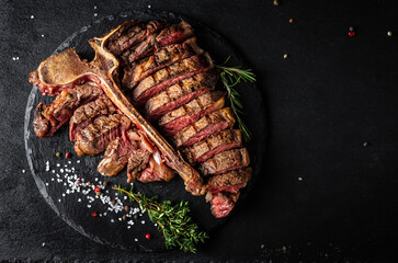 Sliced and roast T-bone or porterhouse beef meat Steak for steakhouse menu on black background....