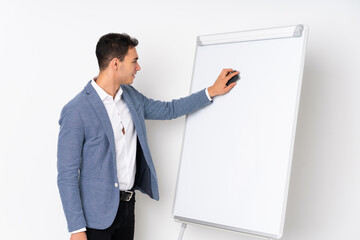 Young caucasian handsome man isolated on purple background giving a presentation on white board