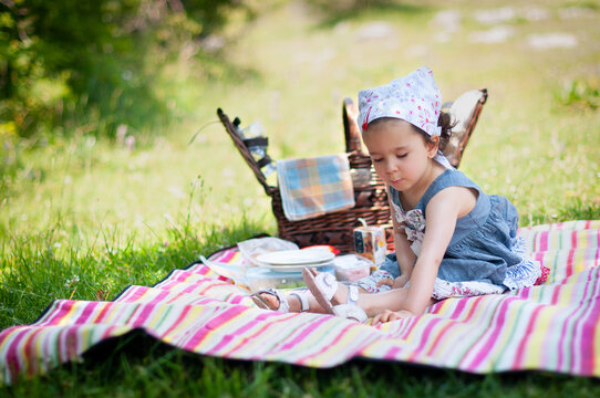 Girl sitting on a picnic blanket in the park, Bulgaria