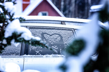 Frozen windshield in the snow with a heart