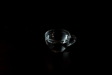 transparent glass cup with water on a dark background. drink in a cup on the table.