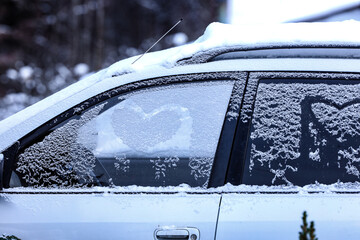 Frozen windshield in the snow with a heart