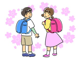ランドセルを背負って振り向く男の子と女の子と桜