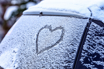 Frozen windshield in the snow with a heart