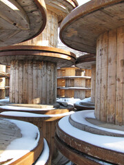 Piles of wood reels covered by snow