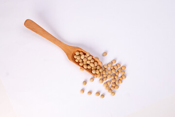 Soya bean in wooden scoop spoon on white background
