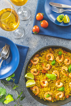 Traditional spanish seafood paella in the fry pan. Dinner served with wine.