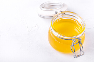 Ghee (clarified butter) in the glass jar against the white background. Ingredient used in Indian and Russian cuisines
