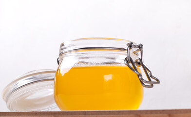Ghee (clarified butter) in the glass jar against the white background. Ingredient used in Indian and Russian cuisines