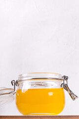 Ghee (clarified butter) in the glass jar against the white background. Ingredient used in Indian and Russian cuisines