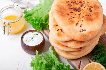 Homemade Naan flatbread with flax seeds on the white table. Indian cuisine bread