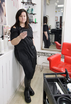 Hairdresser making hairstyle. Cheerful hairdresser working with her client at the small beauty salon.