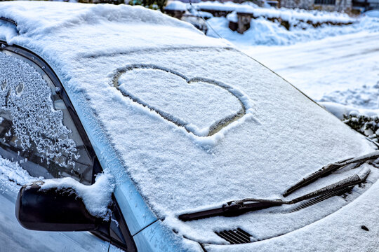 Frozen windshield in the snow with a heart
