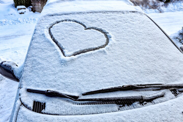 Frozen windshield in the snow with a heart