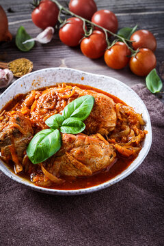 Chicken with tomato and vegetables close-up on plate