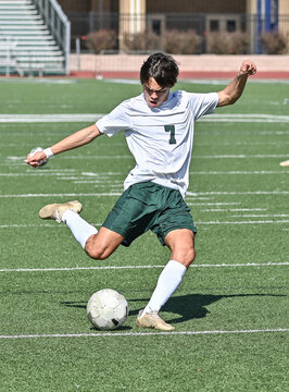Young Athletic boy kicking the ball during a soccer game