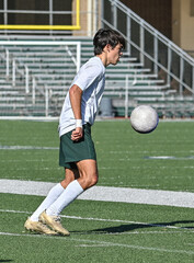 Fototapeta premium Young Athletic boy kicking the ball during a soccer game