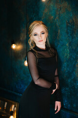 Blonde girl with blue eyes in a black dress © omelnickiy
