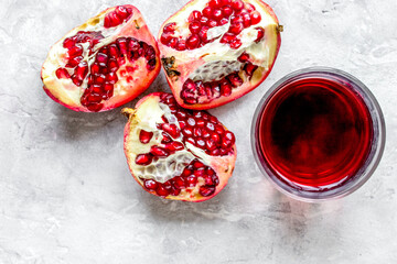 glass of pomegranate juice with fresh slices on stone background top view