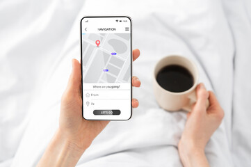 Woman Using Cellphone With Navigation App Browsing Route In Bedroom