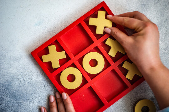 Close-up of a person playing tic tac toe board game