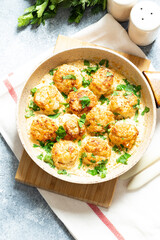 meatballs in white sauce in a frying pan on a gray background, comfortable homemade healthy food