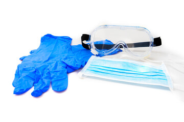 Medical gloves, surgical mask, and goggles on white background.