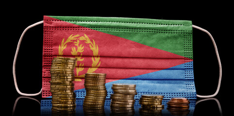 Medical mask with the flag of Eritrea behind some shrinking stacks of various coins.(series)