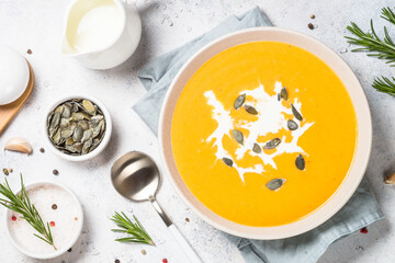 Pumpkin soup with cream. Top view image at white table.