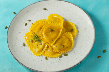 Homemade Pumpkin Ravioli with butter on a light concrete background. Top view
