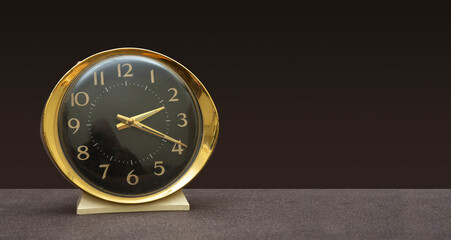 Golden color table clock with gray background - time management concept