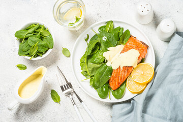 Salmon fillet with spinach and mustard yogurt dressing. Healthy food, keto diet. Top view at white.