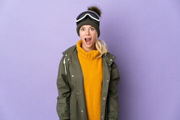 Skier Russian girl with snowboarding glasses isolated on purple background with surprise facial expression
