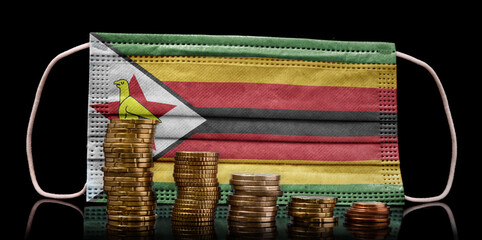 Medical mask with the flag of Zimbabwe behind some shrinking stacks of various coins.(series)